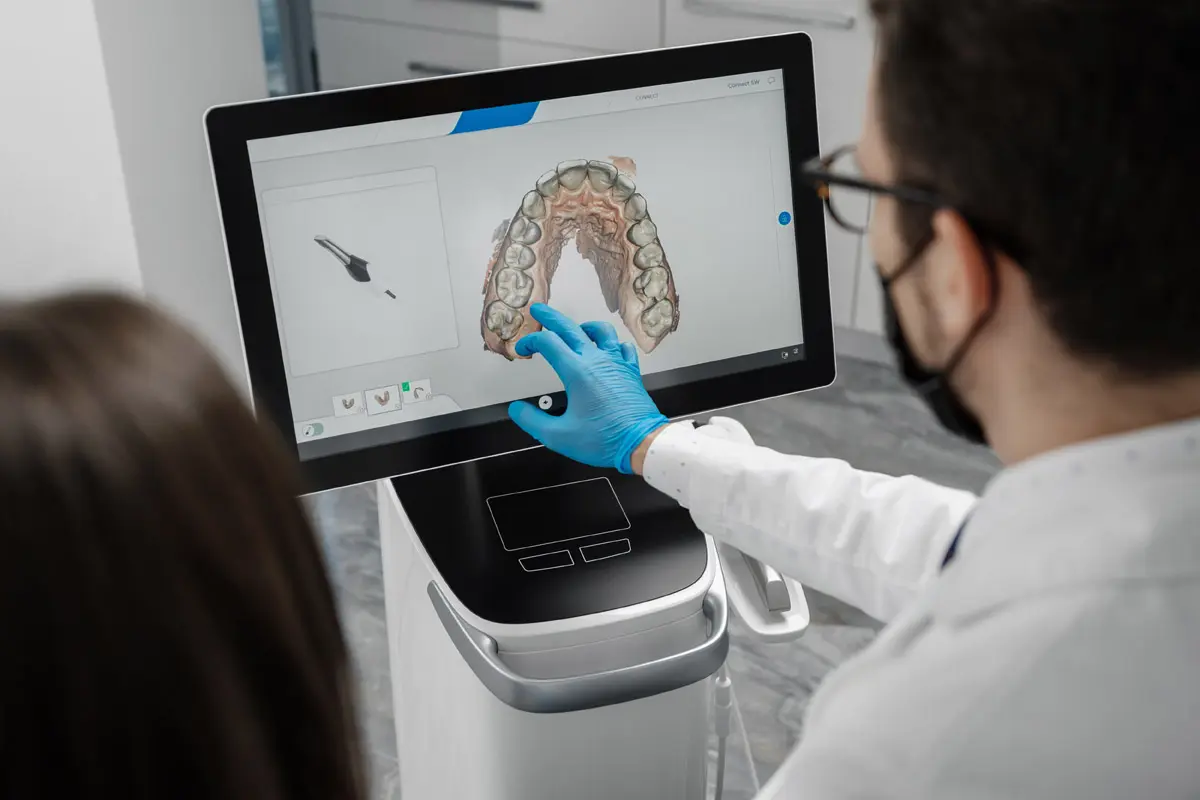 Male doctor show results of digital intraoral scan of patient teeth in 3D on display.
